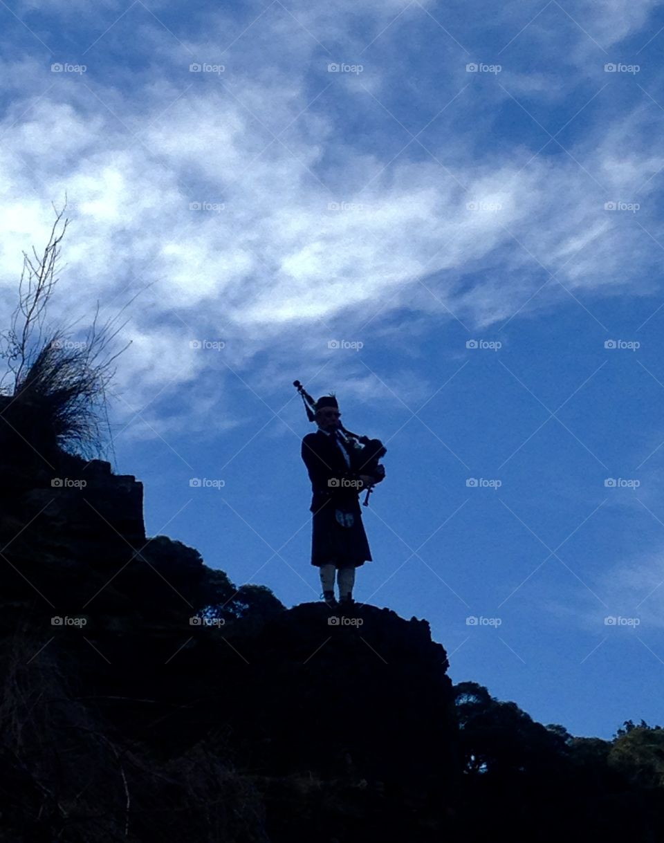 Bagpiper playing high on a hill