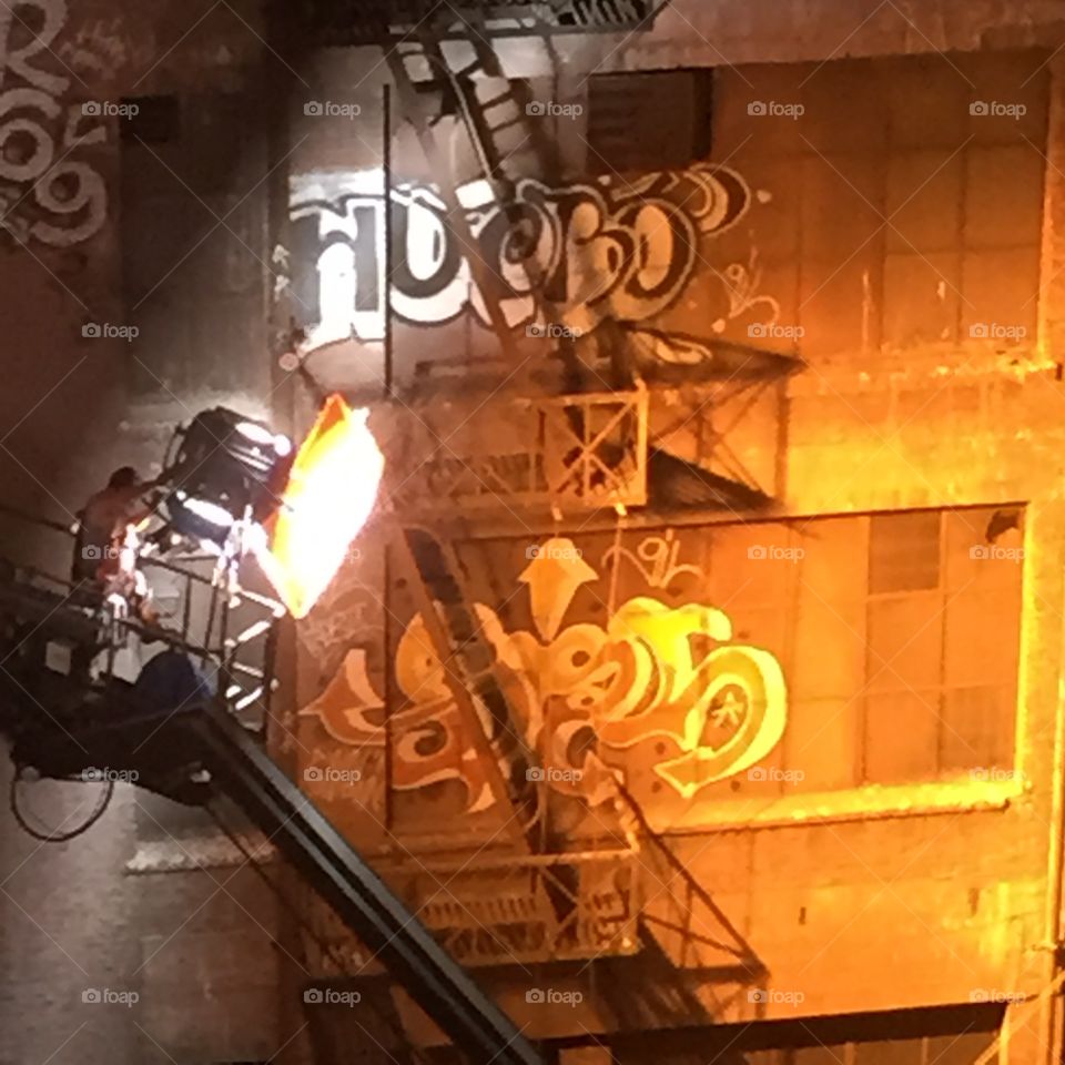Bright lights, little Gaffer. Technically the guy with the light is called a Grip (Gaffers are electricians).  Movie shoot in the alley behind my loft