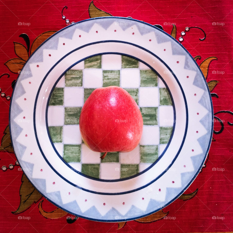 A red apple on a checkered plate