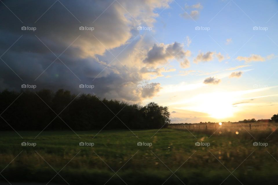 Clouds over the field and the forest 