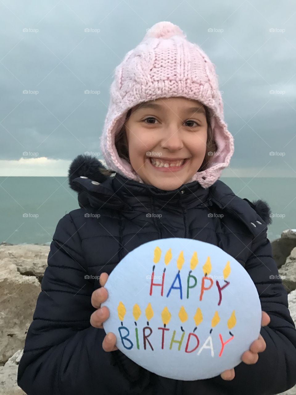 Smiling girl holding pebble stone