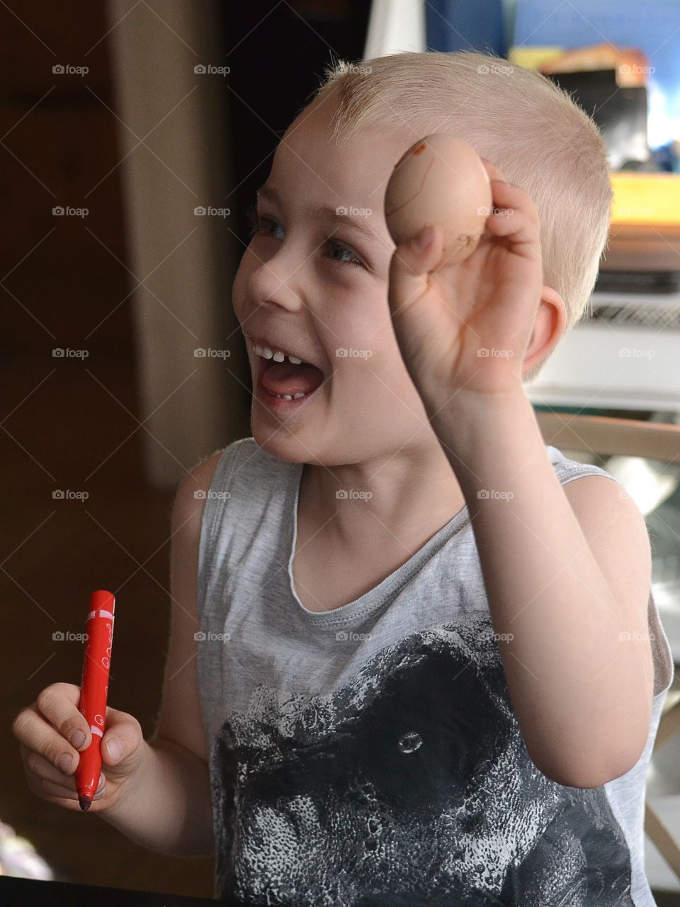 Happy boy painting easter eggs