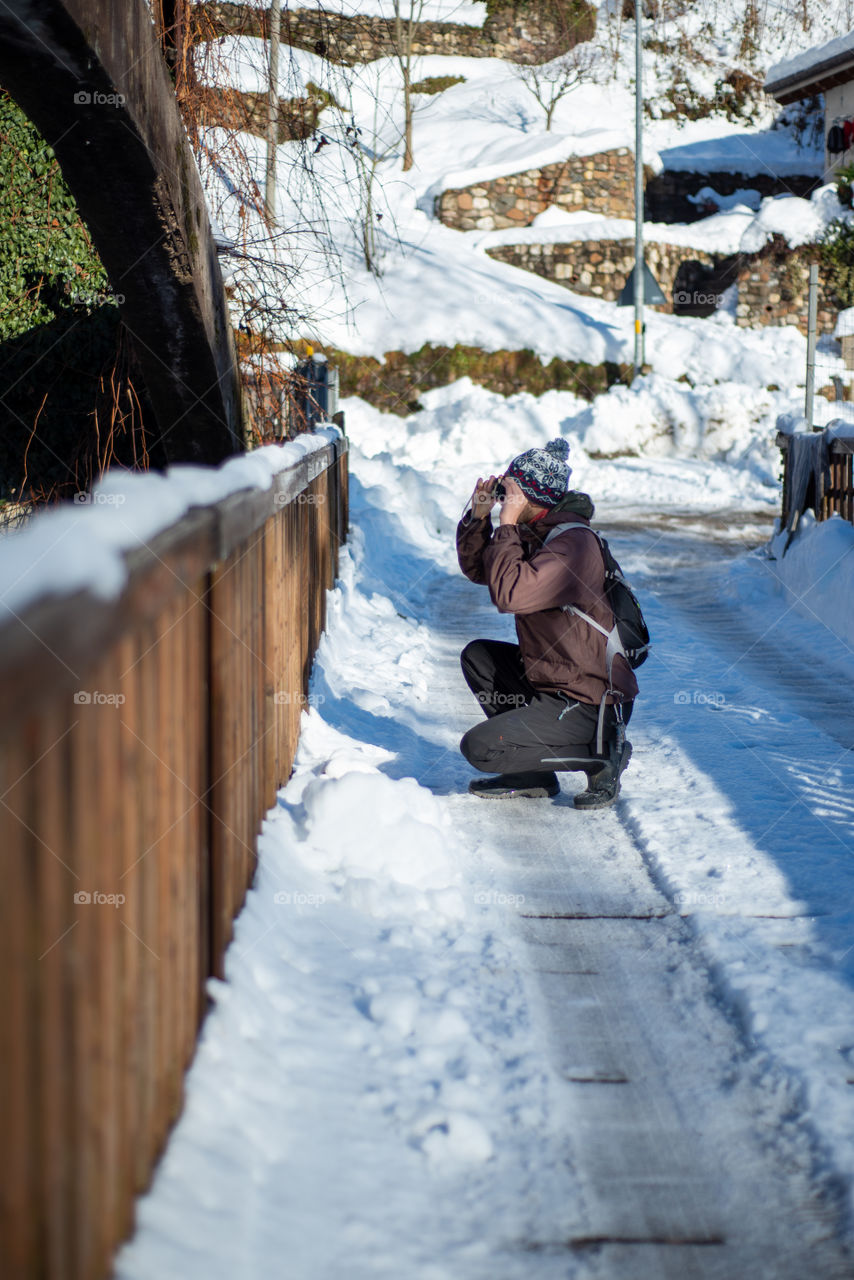 portrait of photographer shooting pictures against snow