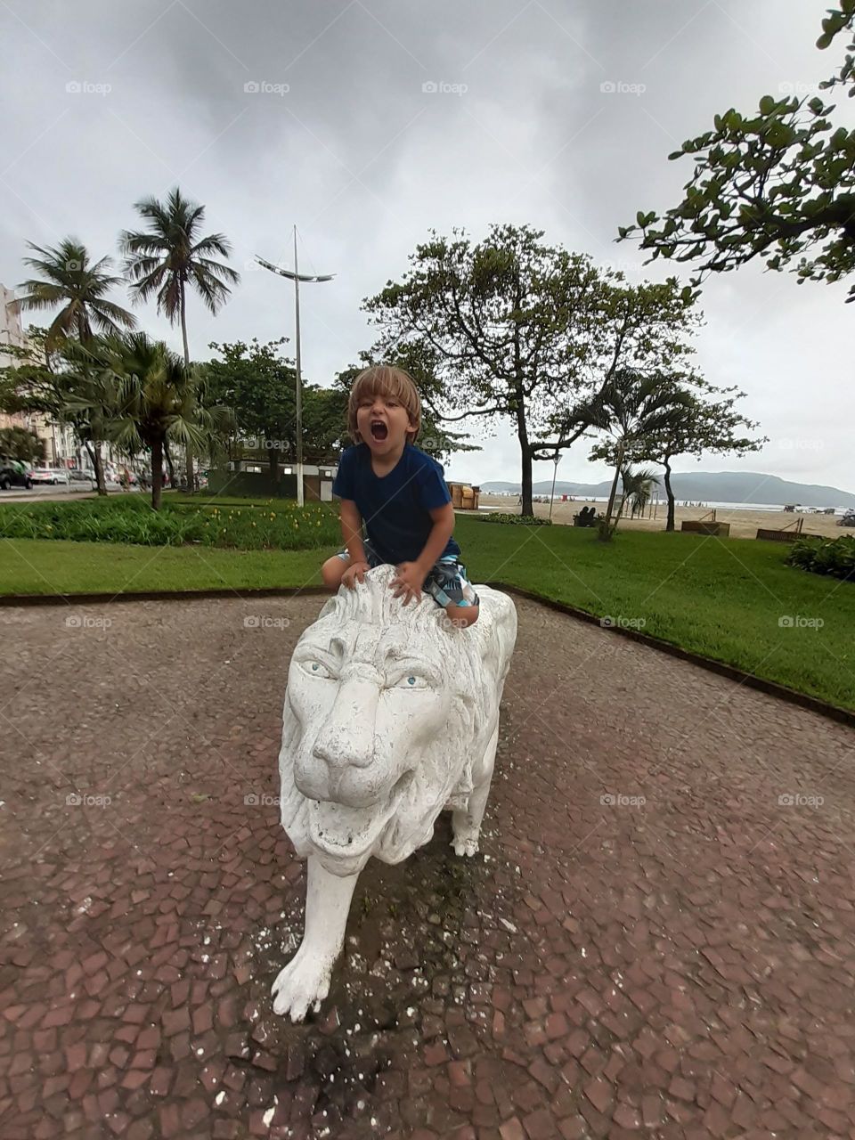 beautiful child on top of a lion in the square in Santos