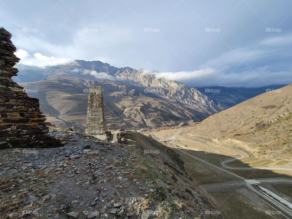 Stone tower and mountain peaks . Travel concept