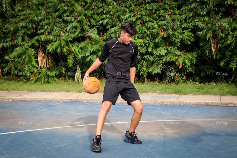 Young man is dribbling a basketball