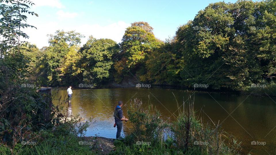 Fishermen in a river, autumn, Wales
