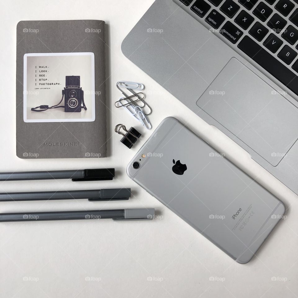 Gray, black and white flat lay with office supplies and technology for a photographer with white space