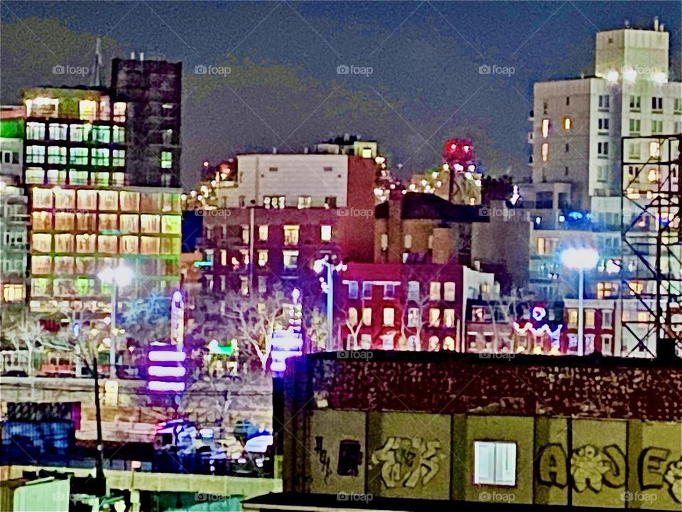 The illuminated cityscape of Long Island City, Queens, NY at night seen from the „Pulaski Bridge“ that spans the East River to connect Queens and Greenpoint, Bklyn. 2021. Hypnotic Productions