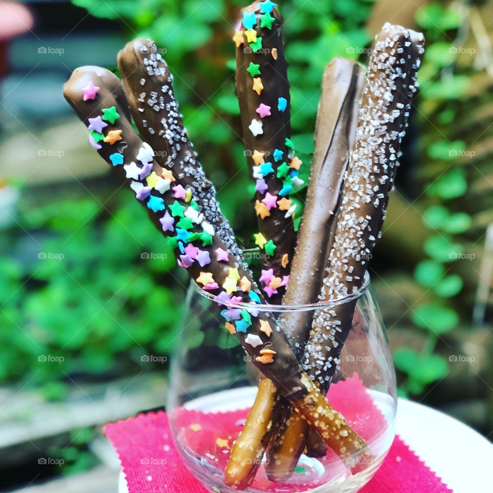 Pretzels covered with milk chocolate. Snack. Tasty treat. Infused food.  Decadent. Colorful  