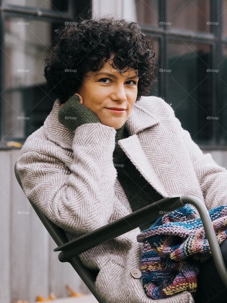 Portrait of young beautiful smiling woman with dark curly hair