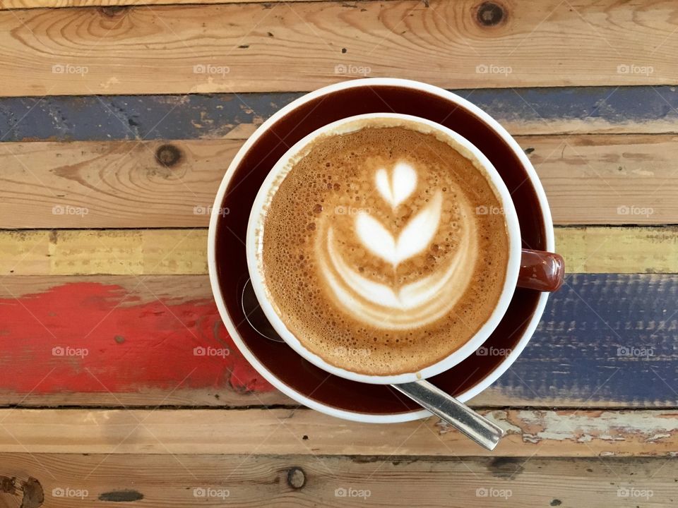 Cup of coffee on colourful wooden table
