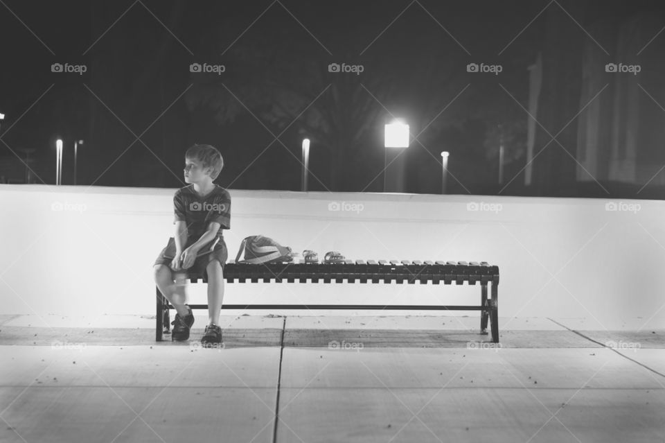 Boy sitting on bench at park