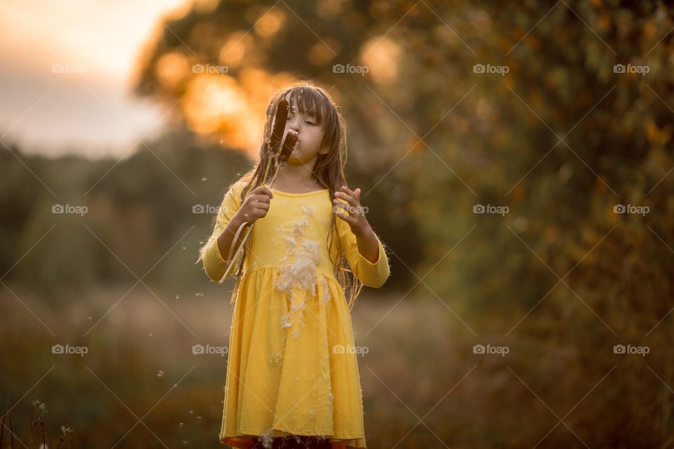 Little girl in yellow dress outdoor portrait at sunset 