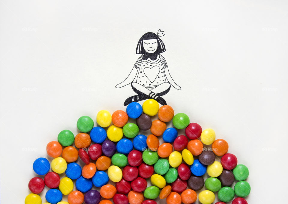 An illustration of a girl sitting on real colorful candies