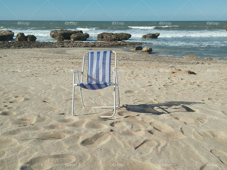 One chair on sand near the beach at essaouira city in Morocco