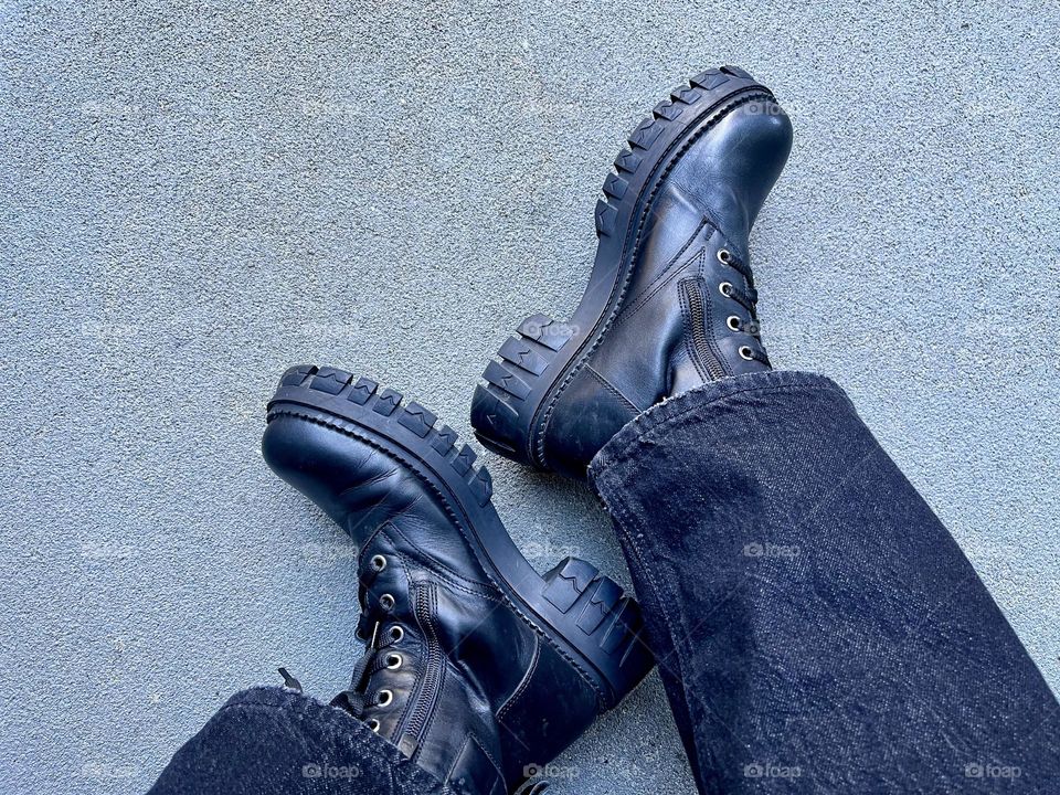 Legs with black boots with tractor sole, top view 