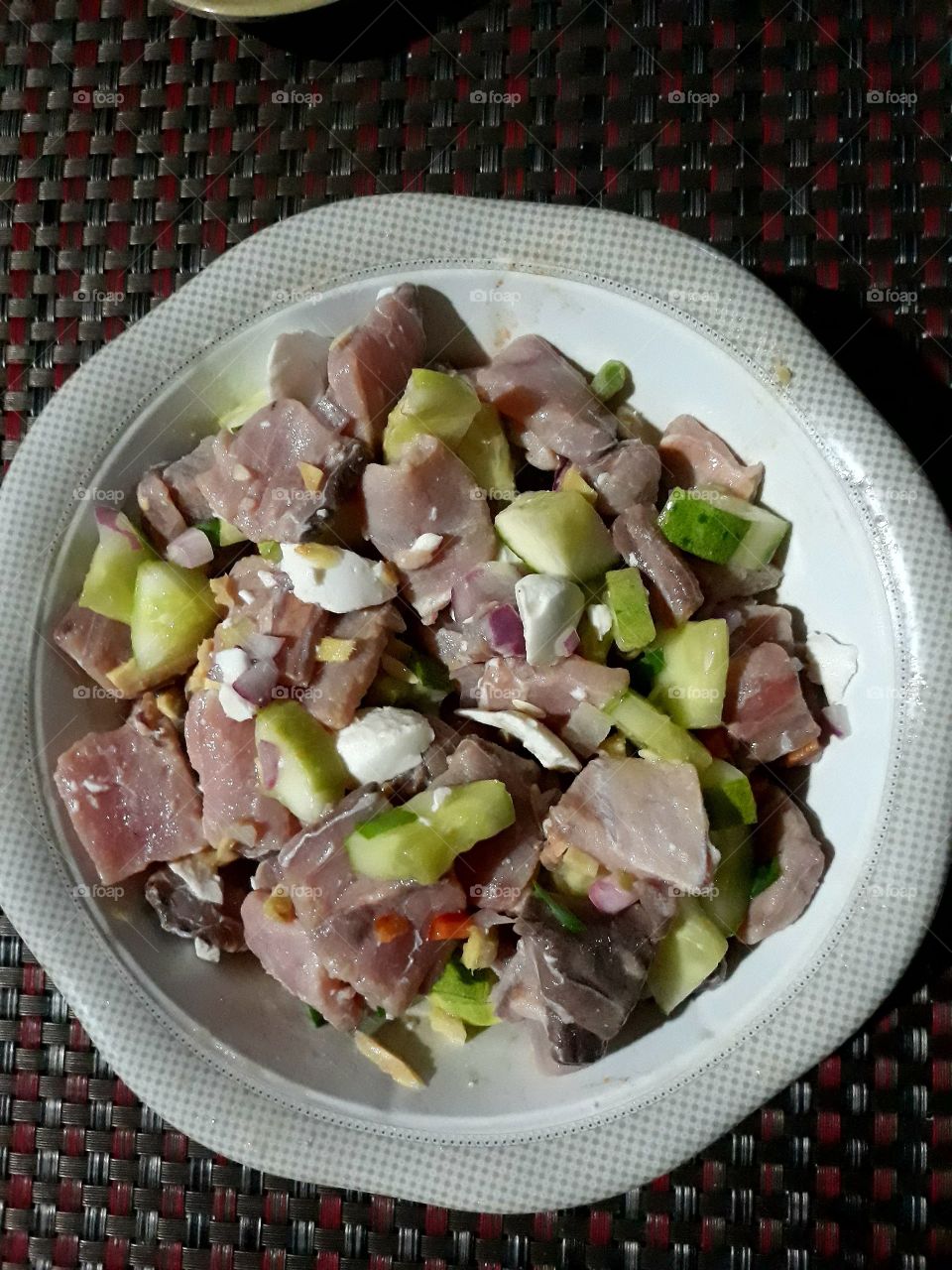 Kinilaw or raw fish salad is a Filipino dish. fresh fish fillet flavored with vinegar, ginger, onions, cucumber.