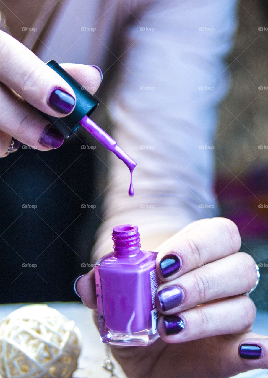 The girl paints nails with varnish