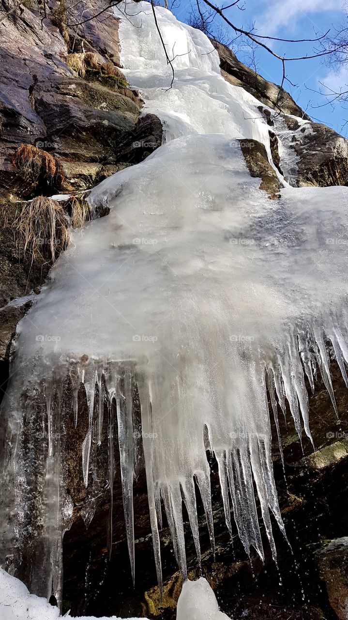 Frozen waterfall on the mountain melting in the spring - fruset vattenfall på berg som smälter i vårsolen 
