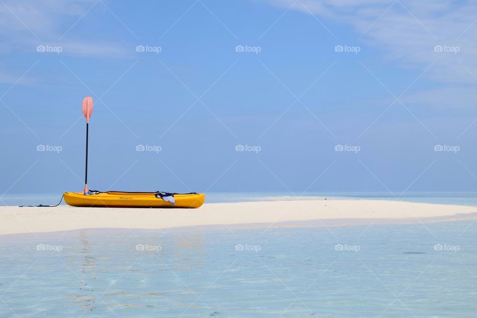 Canoe resting on a sandbar in the middle of the ocean reef