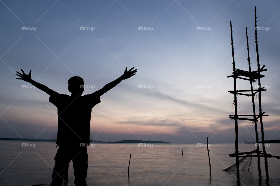 Silhouette man feeling free after sunset
