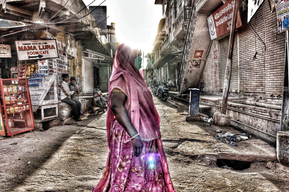 Indian lady crosses street. Pink sari lady crosses street in india 