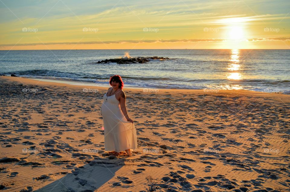 Sunrise Mama. Pregnant woman posing on the beach as the sun rises