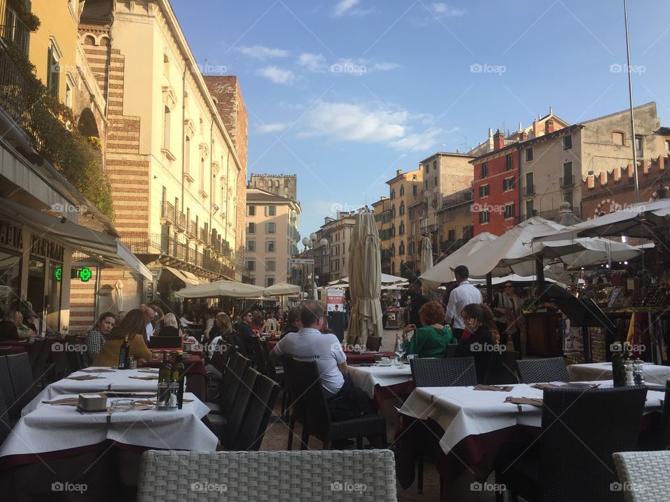 People sitting at tables in a plaza