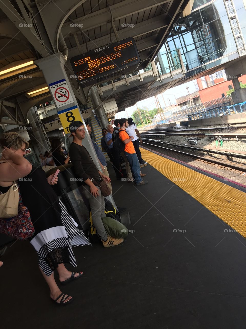 Waiting for the train, subway tracks with commuters, New York.