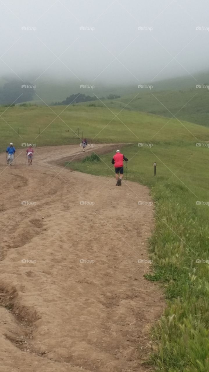 People hiking on a trail on a hill