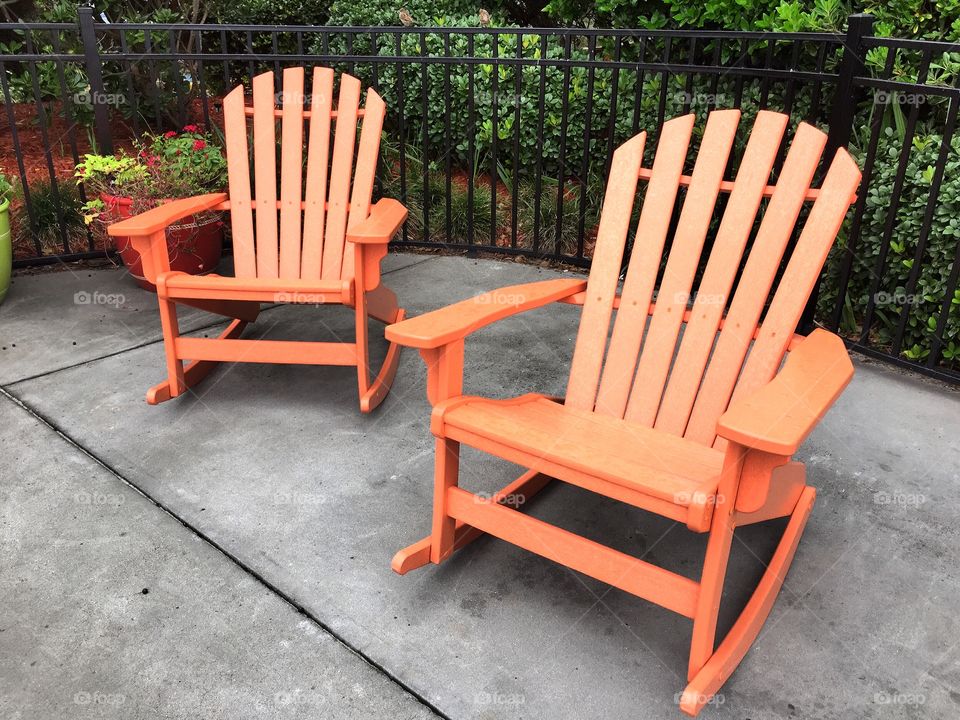 Chairs. Two orange rocking Adirondack chairs.