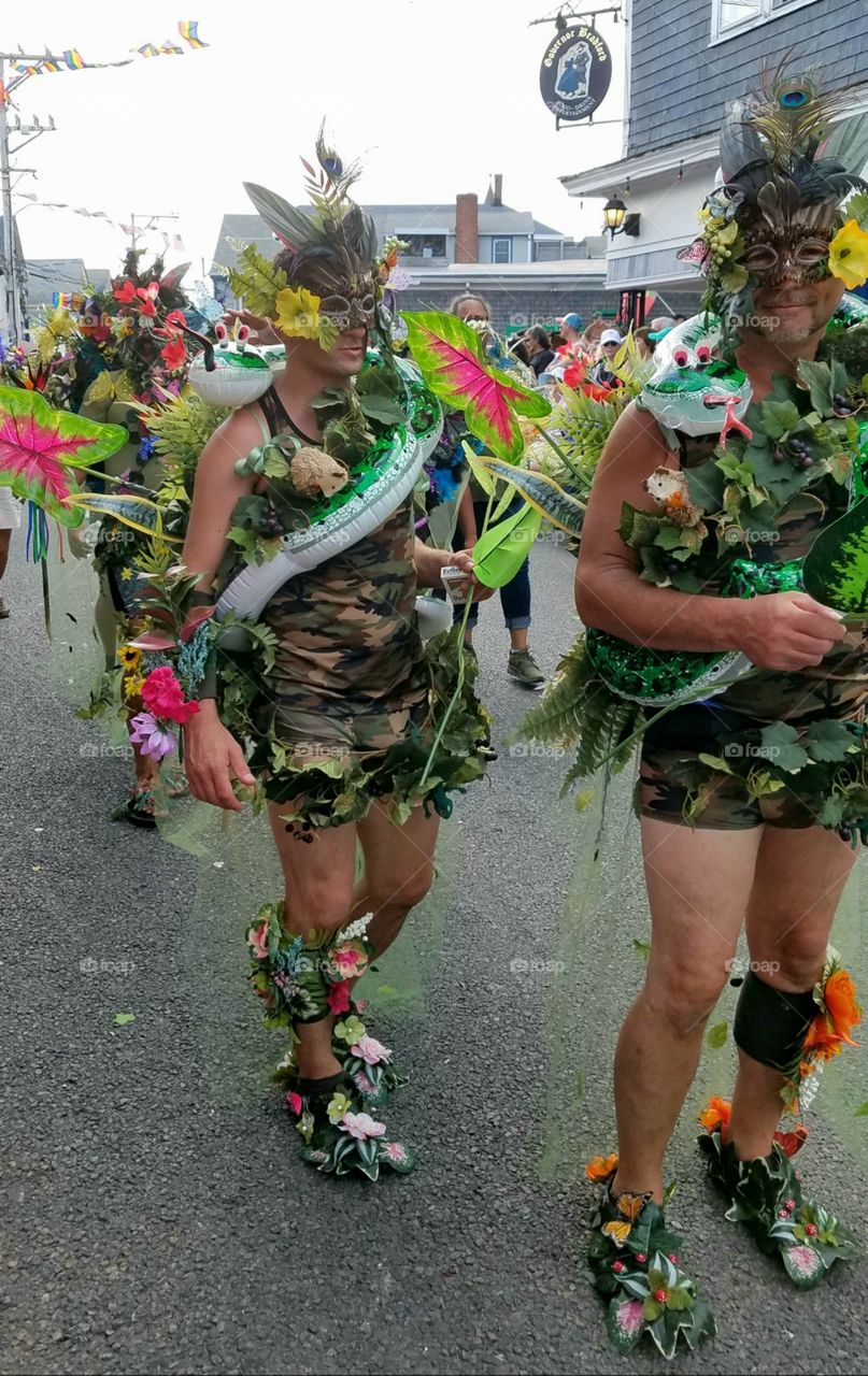 Halloween daytime parade with people in costumes, marching in the streets. Wearing masks and happy facial expressions!
