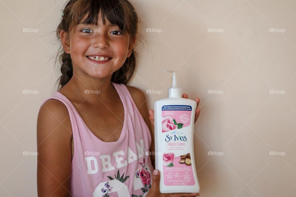 Happy smiling cute girl with St.Ives care product