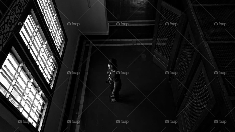 a woman is standing in front of a large window and she is looking at the camera