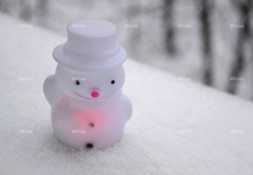 winter holiday light snowman in the snow