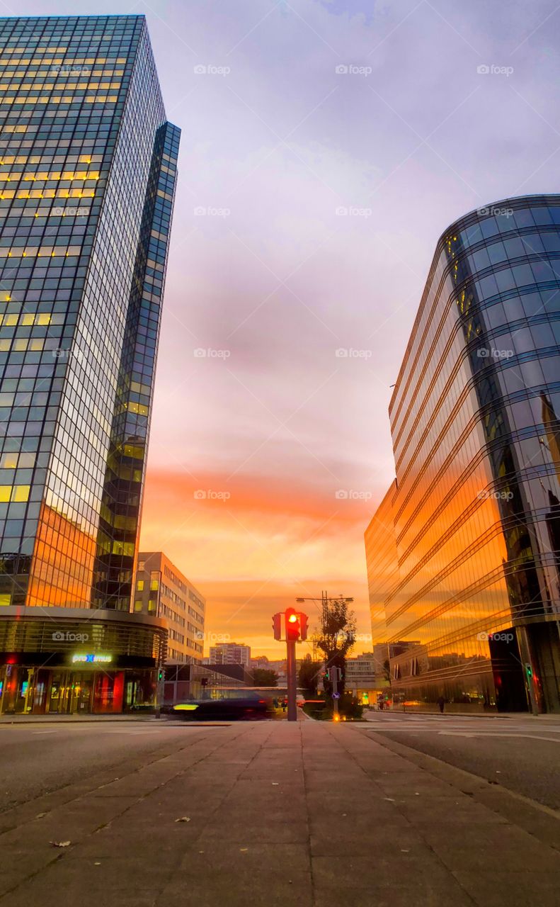 Fiery red sunrise sky over the streets of the city of Brussels reflected in the glass windows of the business office buildings