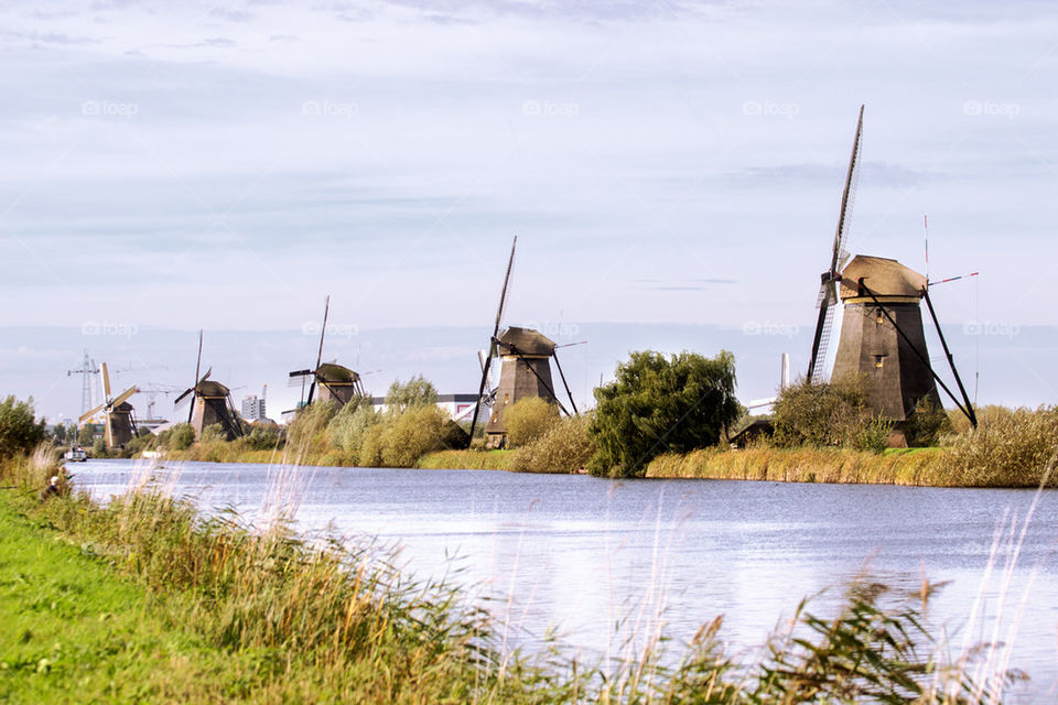 Row of old windmills near the river bank