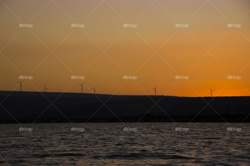 Wind turbines and lovely sunset at shoreline