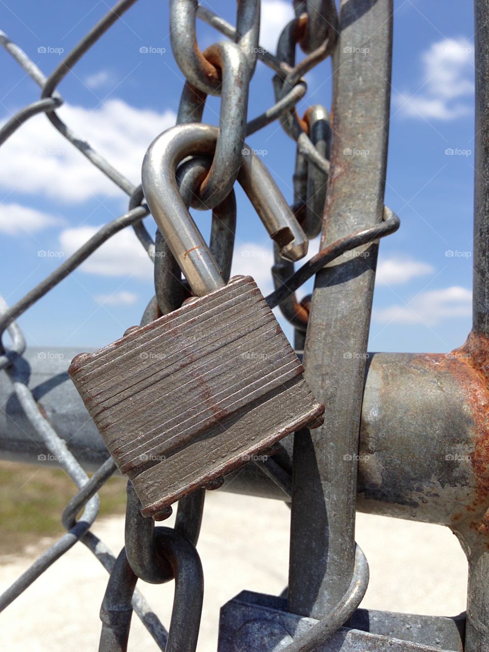 Open padlock on wire fence.