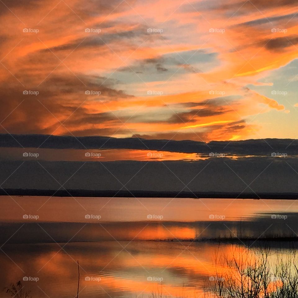 Dramatic sky reflecting on river during sunset