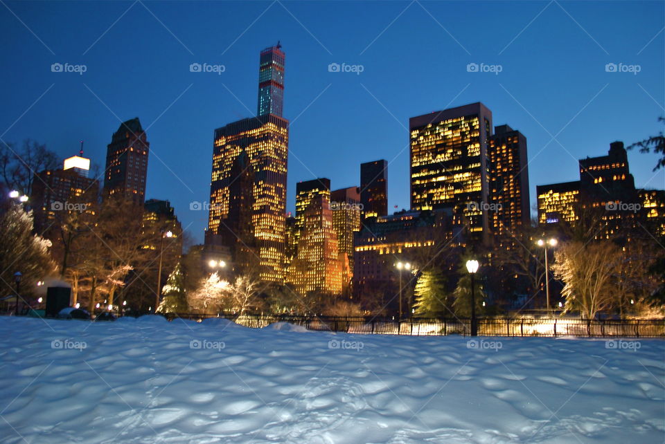 Central Park & 57th. taking a walk on a snowy evening at Central Park in Manhattan with the skycrapers along 57th as backdrop