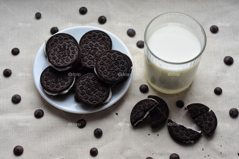 a glass of milk and oreo cookies