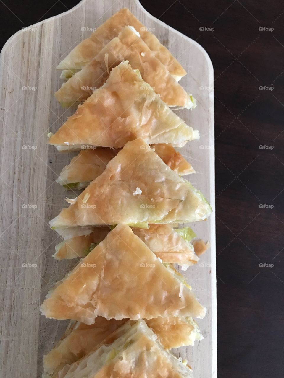 A home made cheese and leek pie , cut on a  triangles shaped pieces