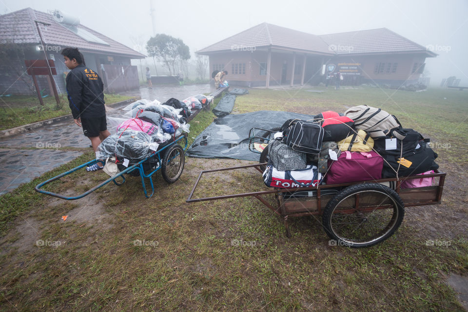 Bag stuff of the tourist that worker carrying up to the hill in Phu Kradueng national park Loei Thailand 