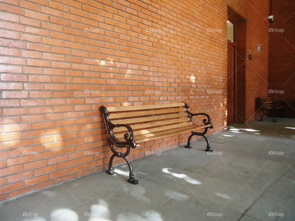 Old fashioned bench. a beautiful old fashioned bench wth a wall behind it