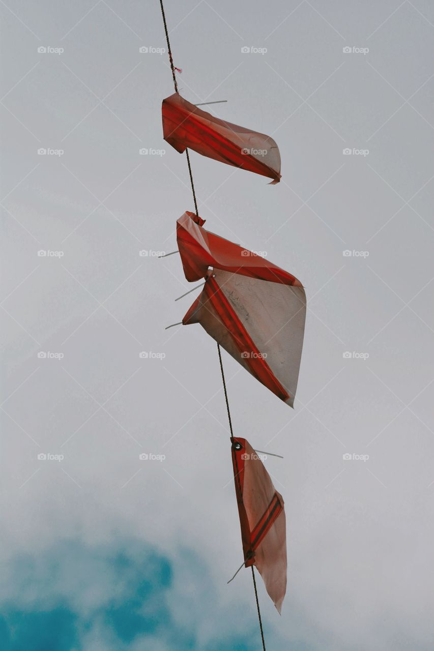 stunning orange ties flags hanging in the sky, great pop of color against white sky  modern 