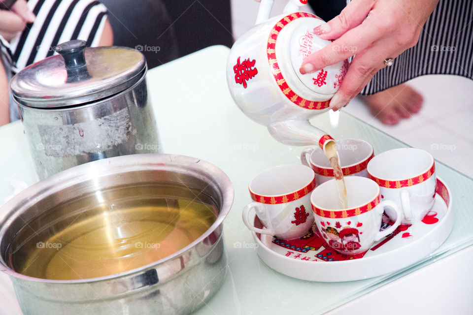 Close-up of hand pouring tea in cup