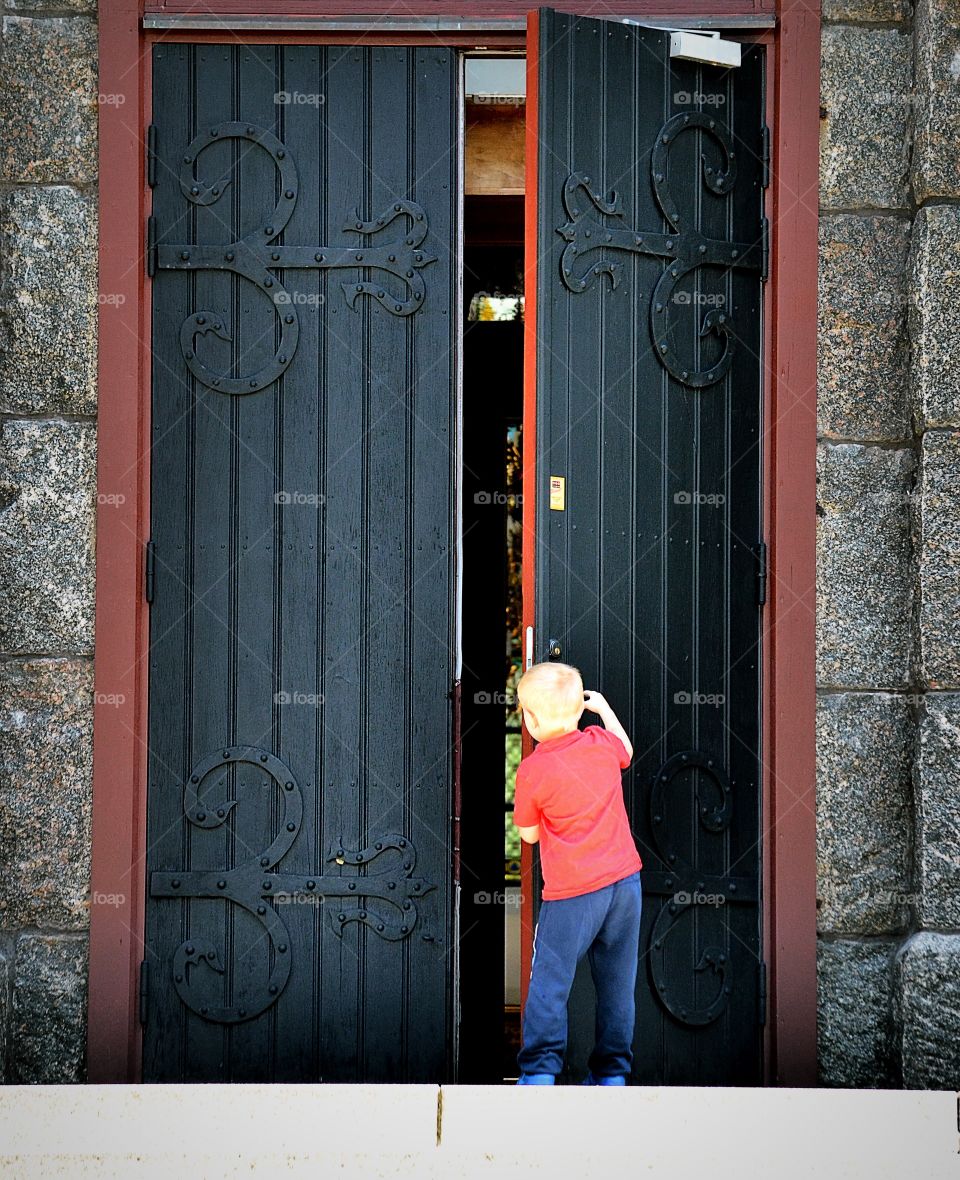 Boy open a big door