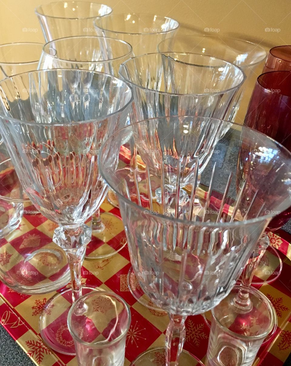 Crystal wine glasses and champagne flutes on red and gold tray. Set up for girls night in party. 